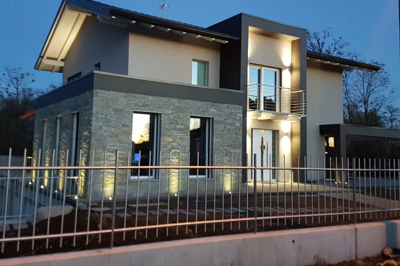 Casa in legno realizzata da EdilAZ, finita, con le luci accese al crepuscolo