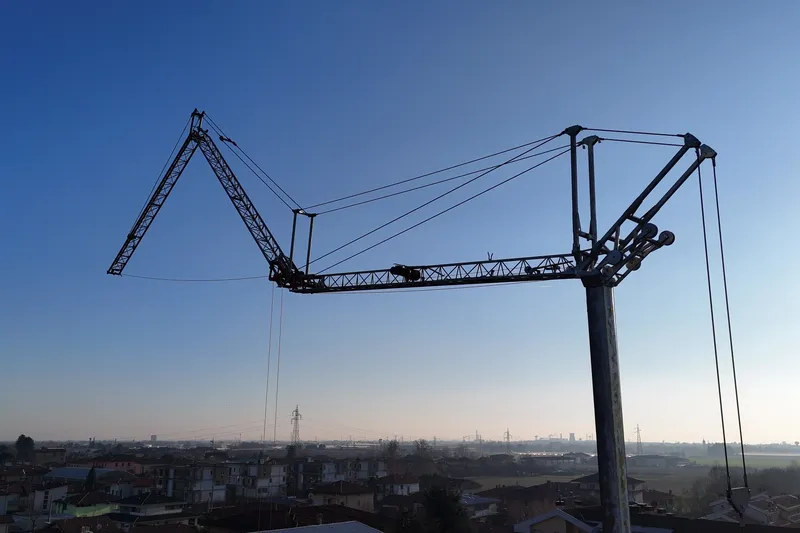 Gru automontante Gelco Clever Crane montata, in controluce al tramonto